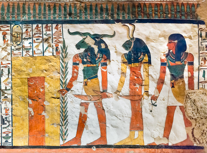 A photo of one of the walls of Queen Nefertari's tomb, depicting three guardian demons. All three are humanoid, with one having a human head, one with a ram's head, and one with a lioness's head topped by two snakes.